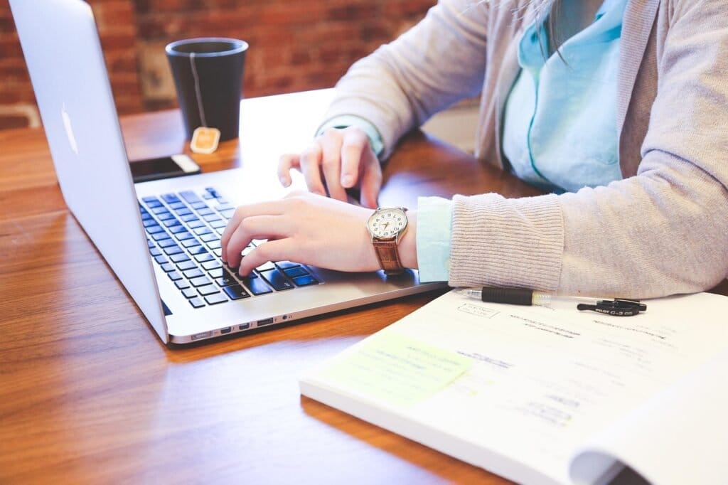 Buying paperwork and notes beside a laptop
