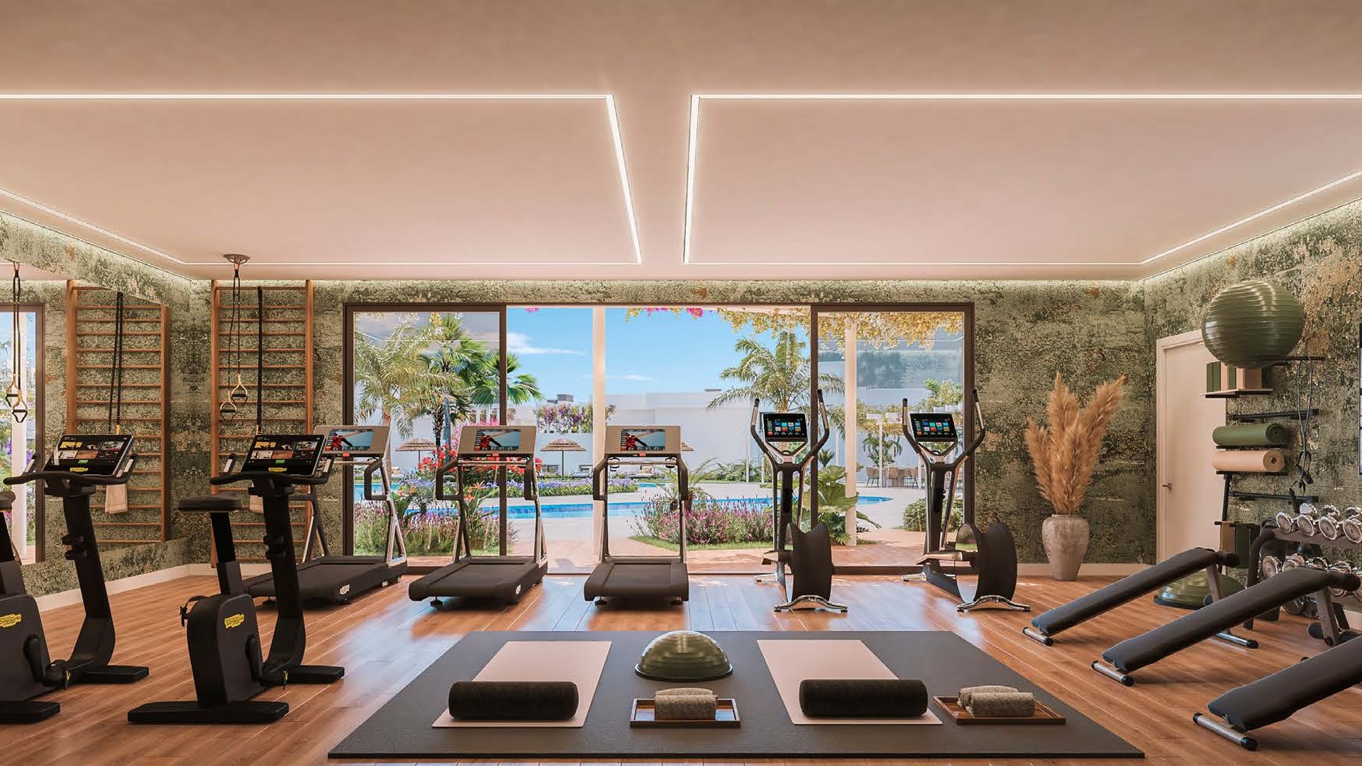 The gym, its running machines and weights set along a wall of glass that looks onto the pool. Amaranta Living, Casares Costa Golf, Casares.