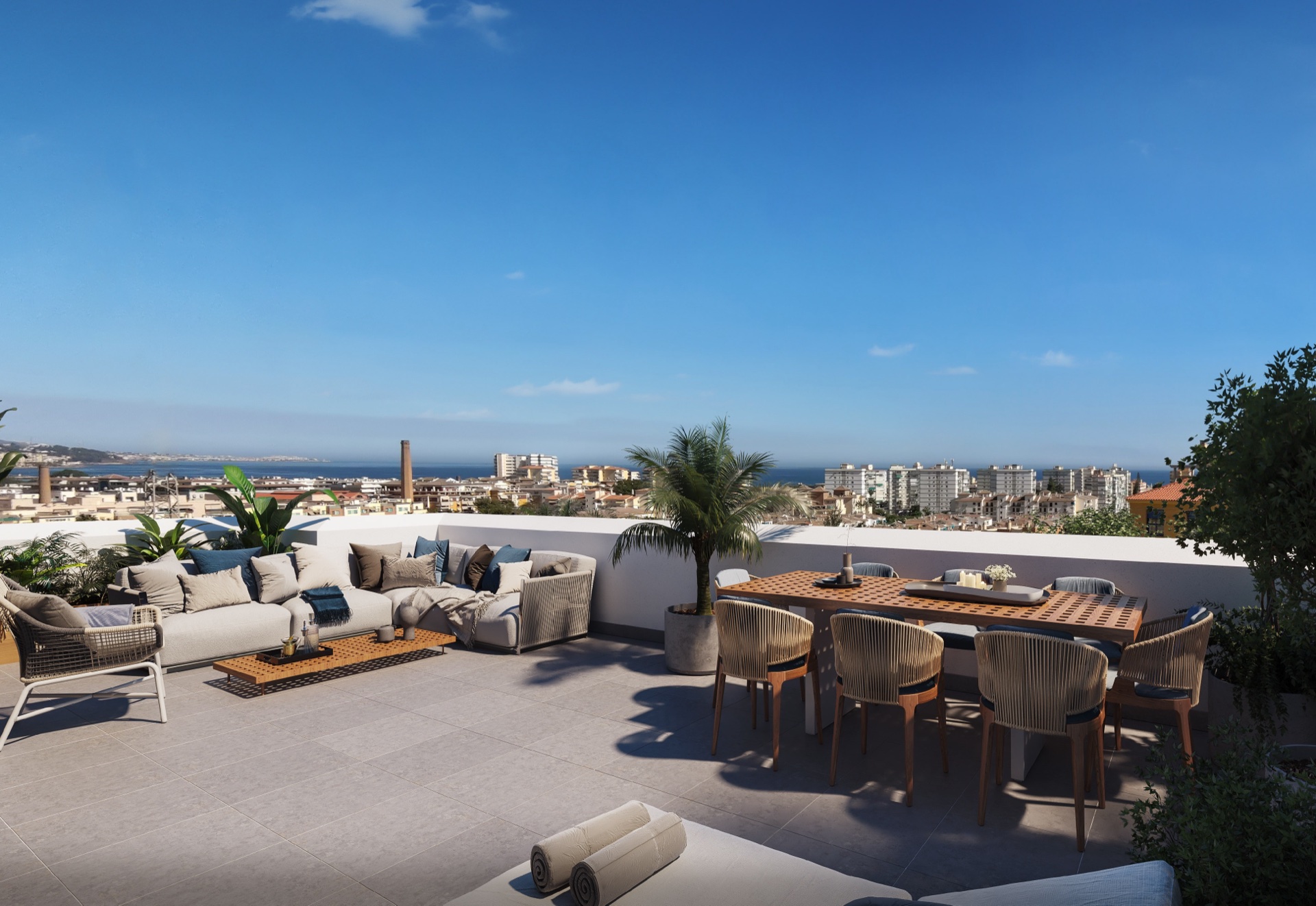 A private roof terrace on one of the top floor homes, with a dining table and a seating area above the rooftops. Aquamar, Cerro del Águila, Torre del Mar.