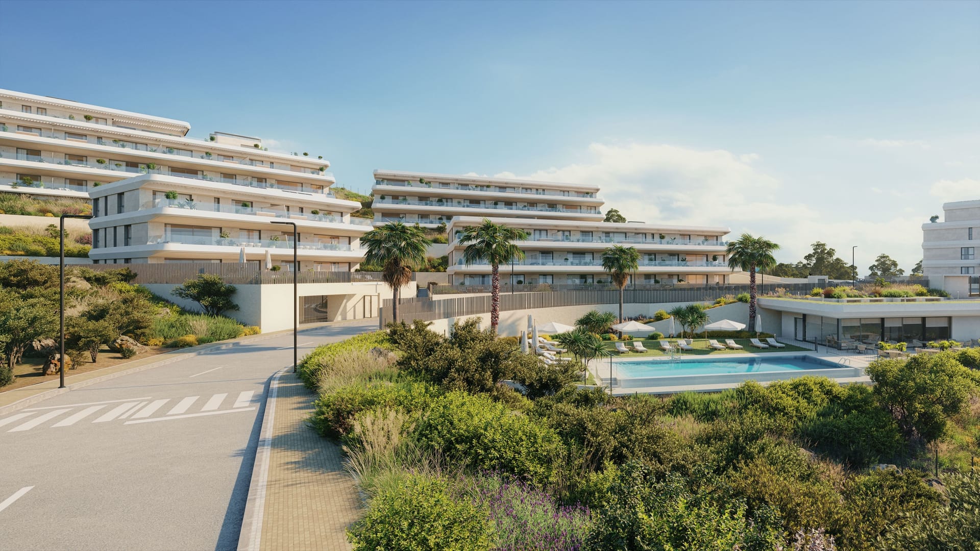 The pool among planted gardens, with the apartment buildings stepped up the slope behind. Australy Aures II, La Resina, Estepona.