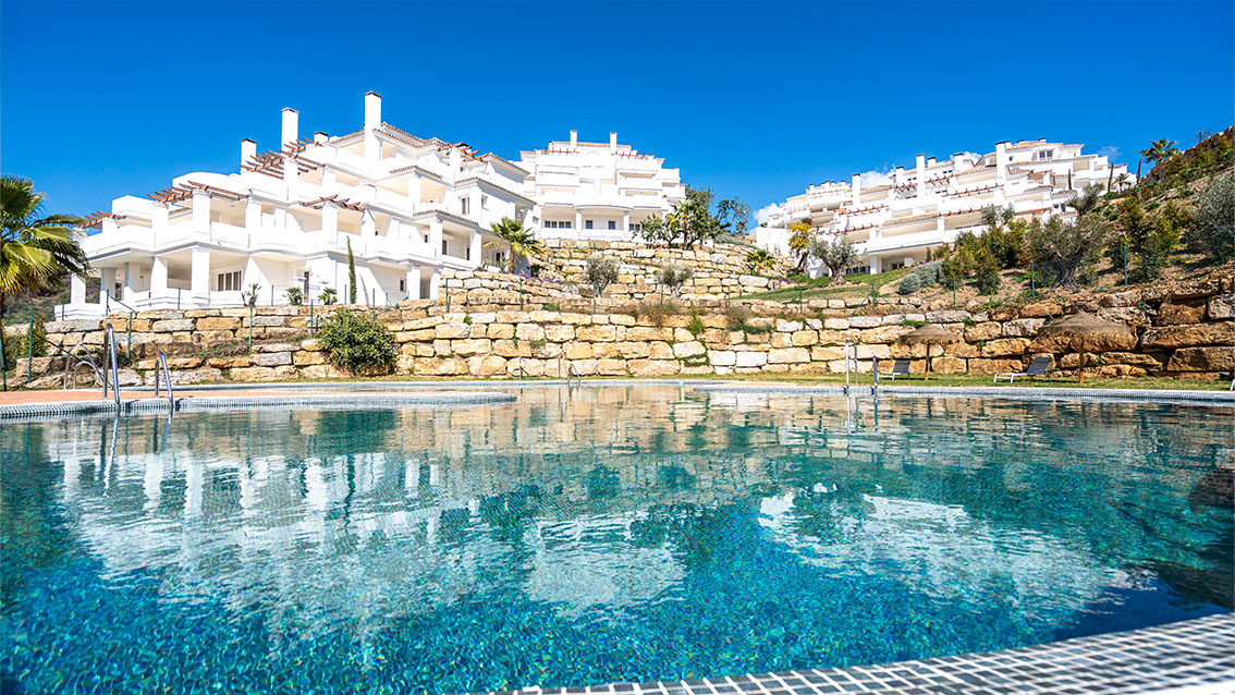 One of the two pools, below the white buildings and the stone walls of the gardens. Be Aloha, Nueva Andalucía, Marbella.