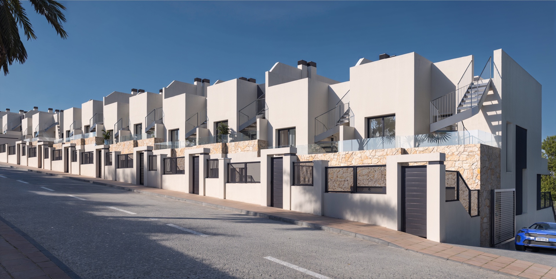 The gated frontage onto the internal street, stone faced below the first-floor terraces. Cala Golf, Entrerríos, Mijas.