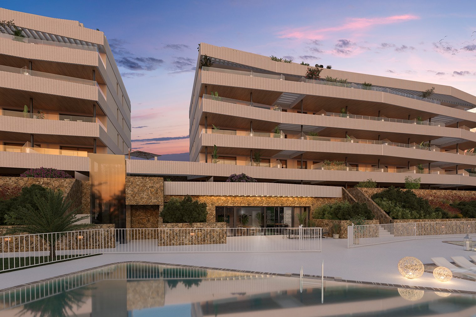 The buildings above the pool at dusk, each floor of terraces set back from the one below. Coto Homes, El Coto, Mijas.