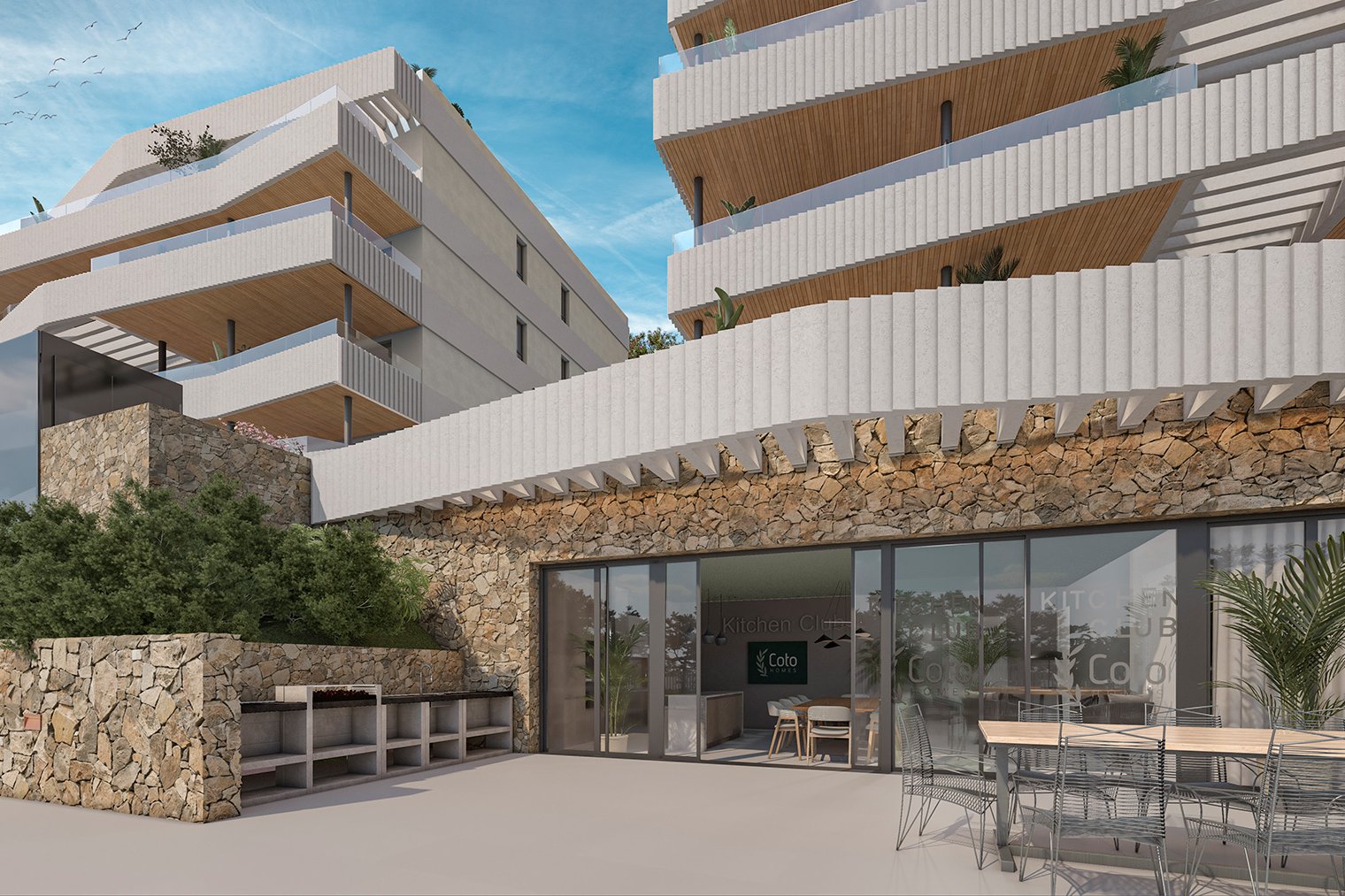 The kitchen club at the foot of the buildings, its barbecues built into a stone wall and a long table out on the terrace. Coto Homes, El Coto, Mijas.
