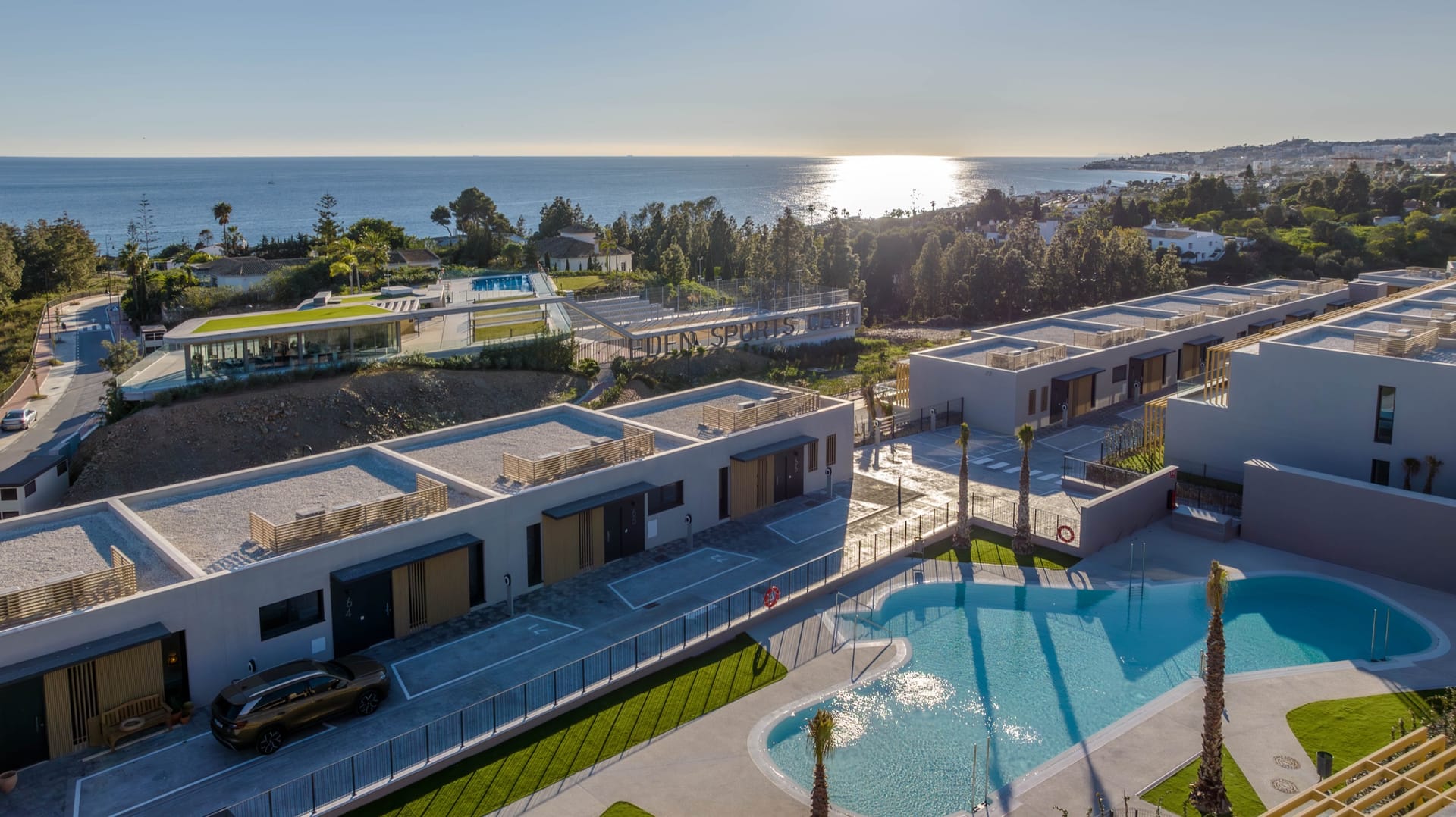 An aerial view of the houses and the pool, with the sea beyond. Evergreen Homes, El Chaparral, Mijas.