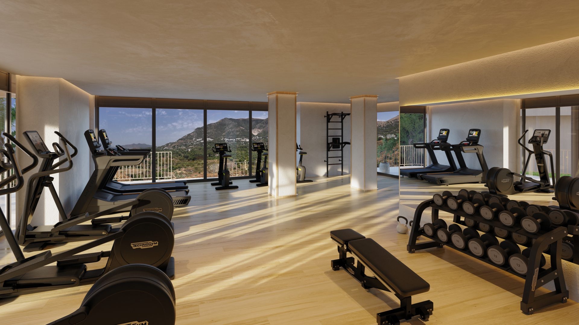 The gym, fitted with cardio machines, free weights and a bench, looking out over the hills behind the site. Evoque Residences, El Higuerón, Fuengirola.