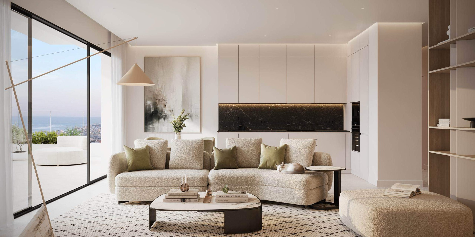 An apartment’s living room, with a curved sofa, white kitchen units and a dark marble splashback along the back wall, and a wall of glass on the left opening onto a terrace that looks over the town to the sea. Horizonte Village, Buenavista, Mijas.