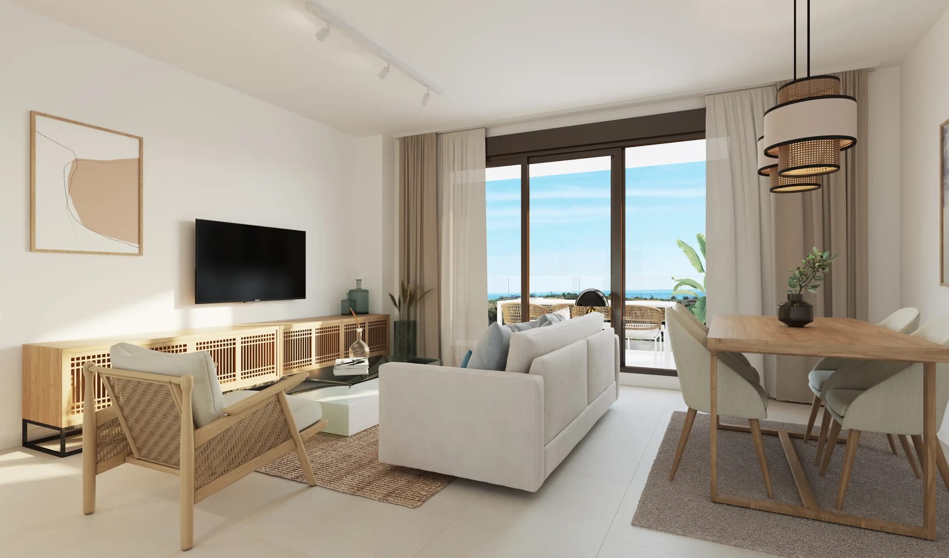 The living room, with the dining table beside glass doors that open to the terrace and the sea. Idilia Terram, Torre de Benagalbón, Rincón de la Victoria.