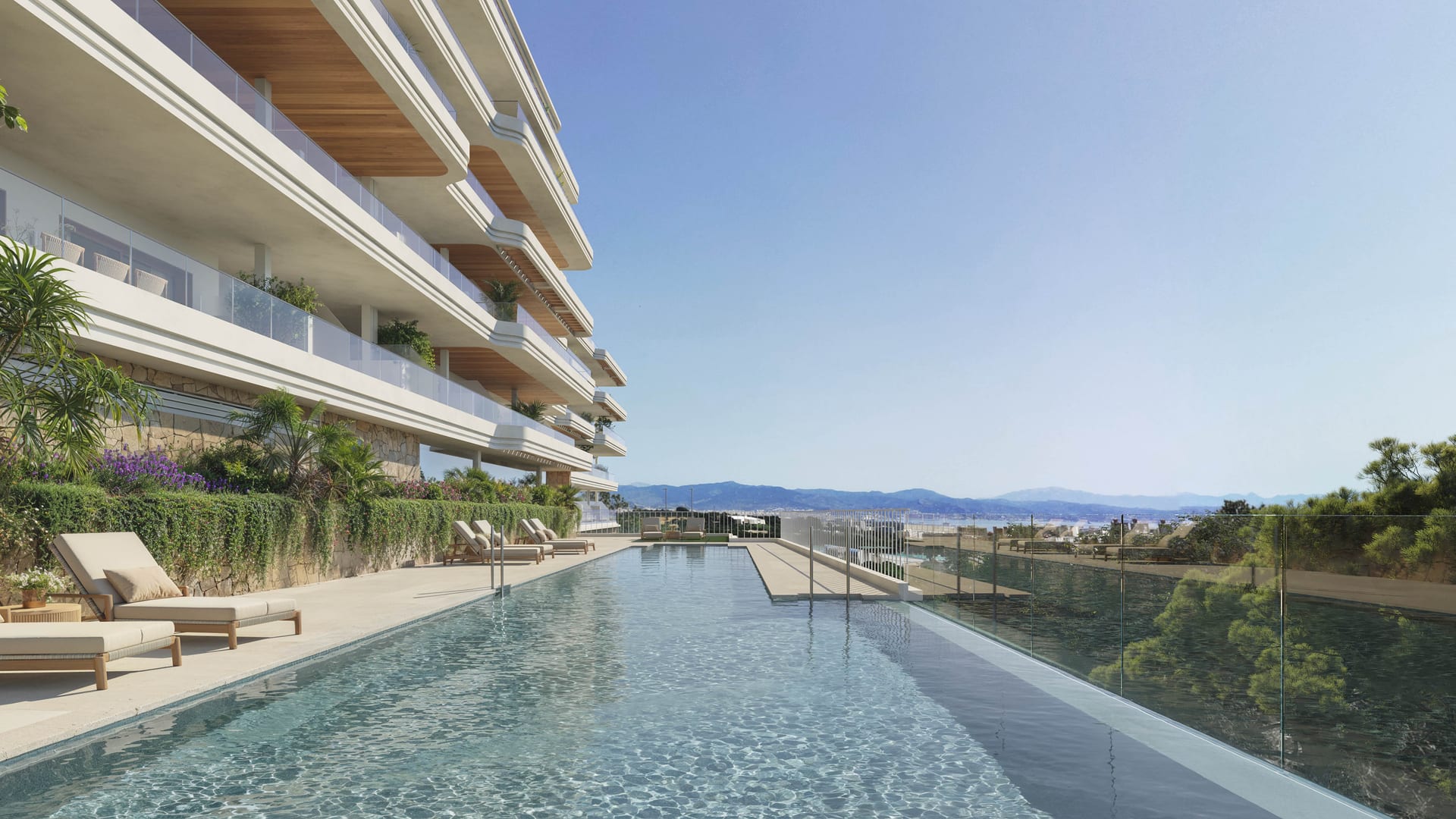 The outdoor pool, with loungers along one side beneath the curved terraces of the building. Kosmos, El Pinillo, Torremolinos.