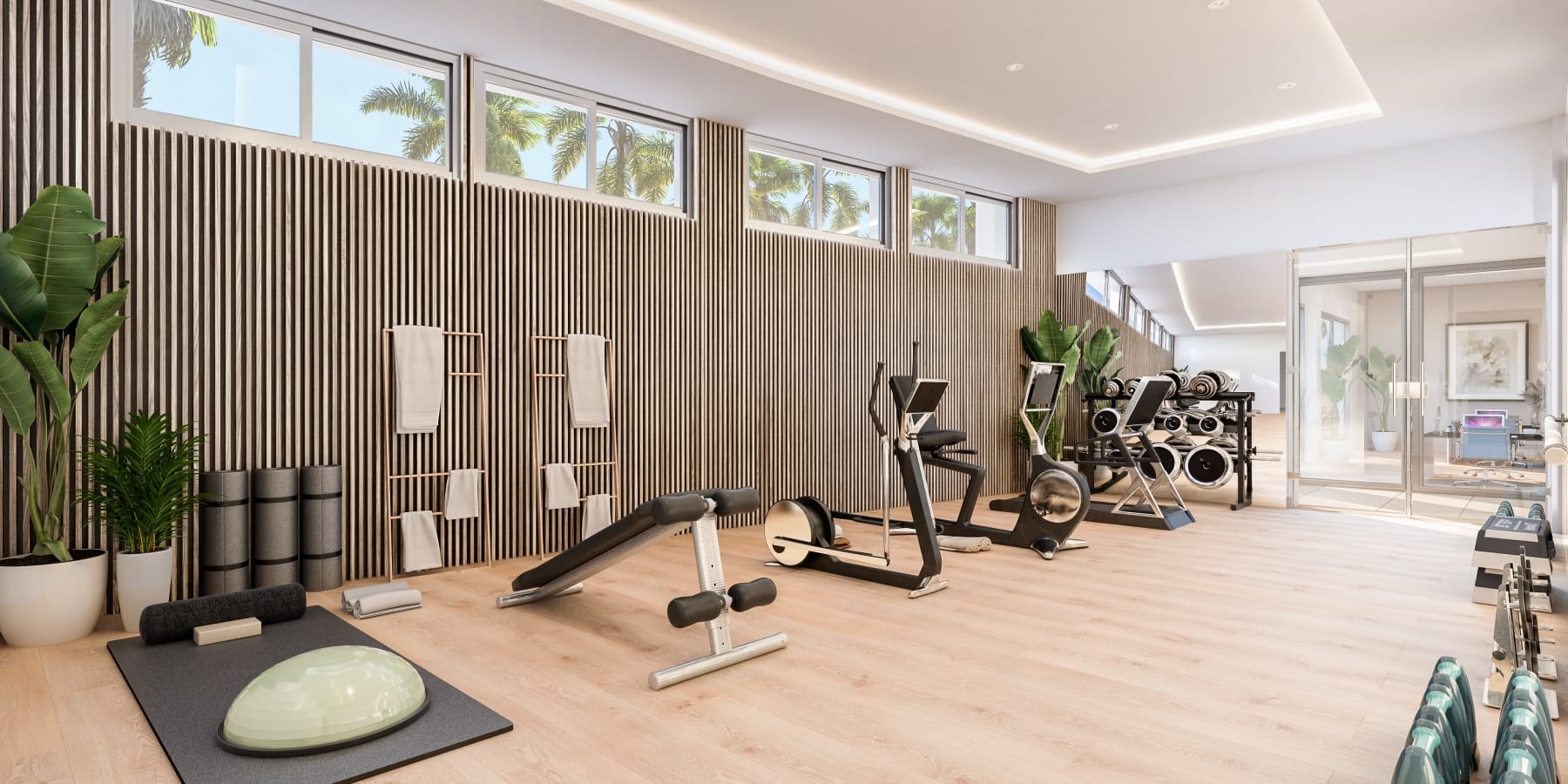 The gym, in the developer’s illustration, with a weights bench and cardio machines under a row of high windows. Lomas del Higuerón 3, El Higuerón, Fuengirola.