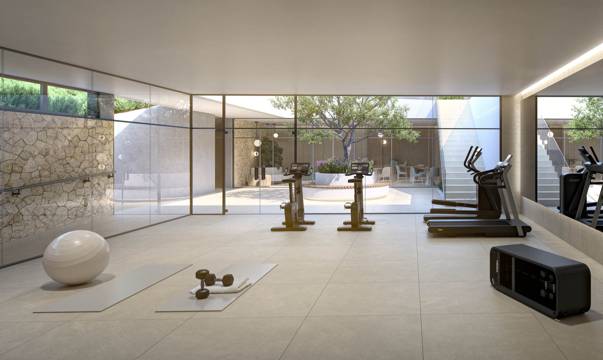 The gym, with machines on a pale floor and glass walls onto a planted courtyard. Naya Residences, Atalaya, Estepona.