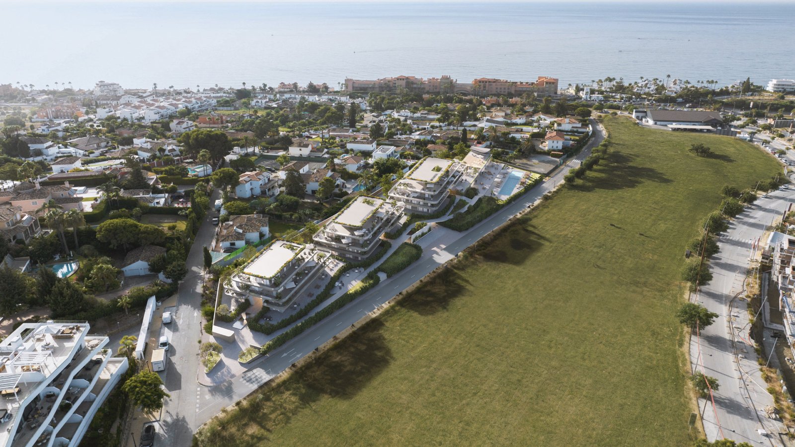 An aerial view of the buildings along their road, with the pool at the far end and the sea beyond. One Estepona, La Gaspara, Estepona.