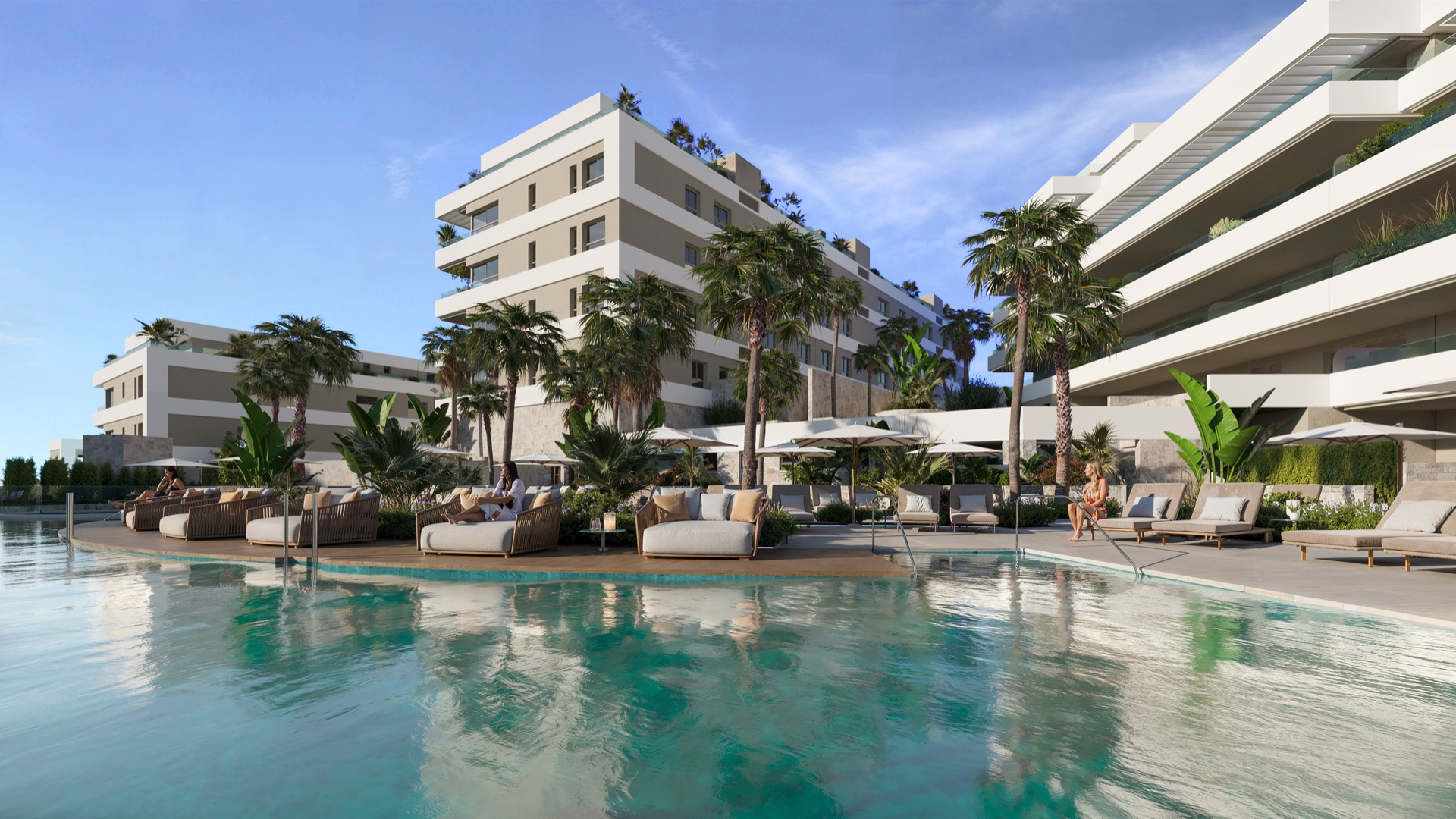 The outdoor pool and its sunbathing deck, with loungers and parasols in front of the buildings. Riviera Hill, Riviera del Sol, Mijas.