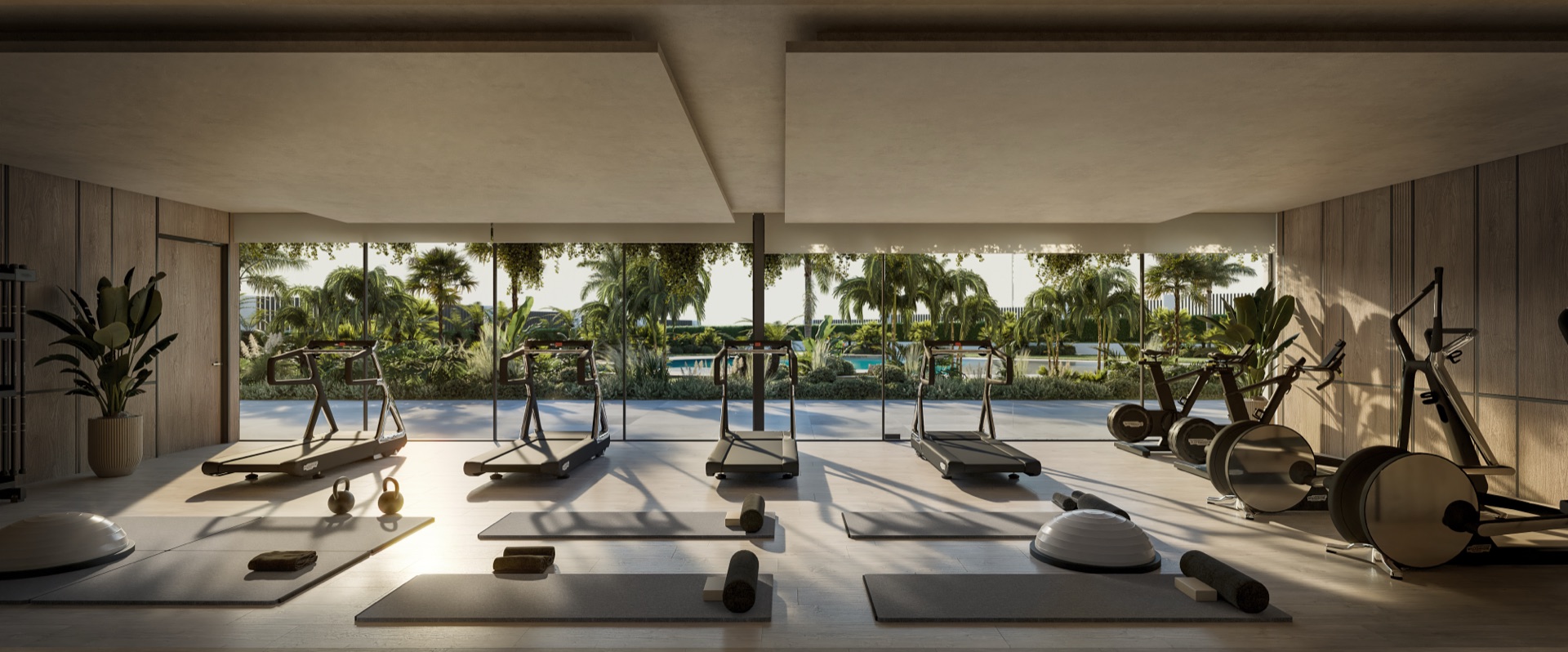 Treadmills and exercise bikes in the gym, which has glass along one side facing the garden and the pool. Solaia Residence, Cancelada, Estepona.