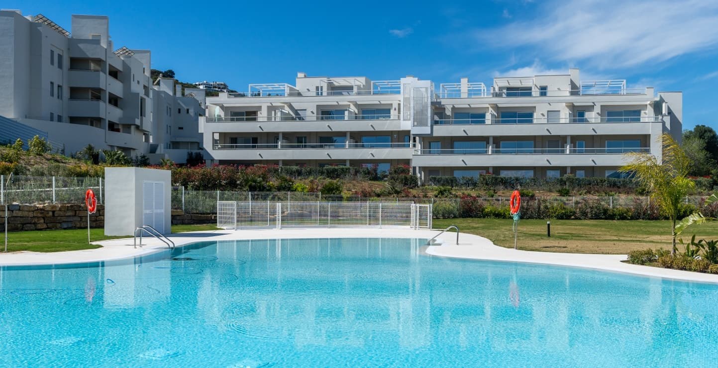 The pool and lawn in front of one of the buildings, whose terraces look out over it. Solana Village, La Cala Golf, Mijas.
