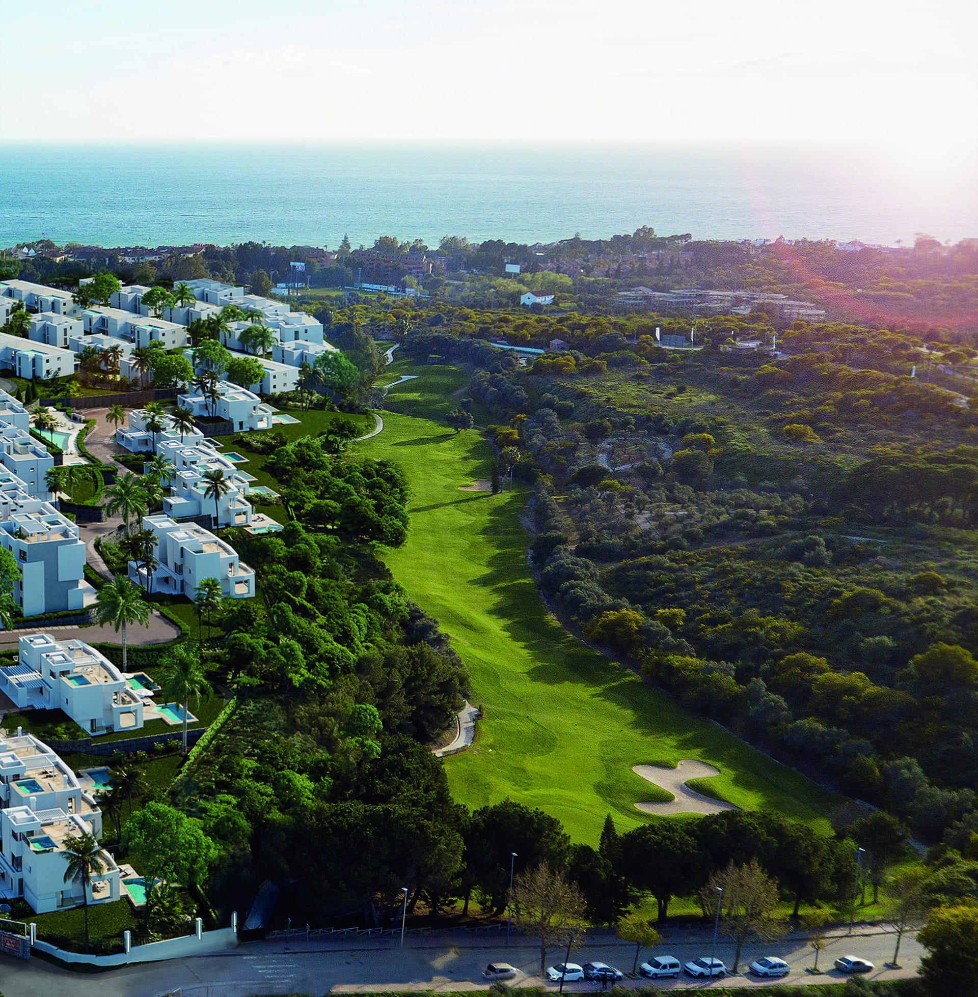 An aerial view of the white buildings of the wider development beside a golf fairway, with the sea beyond. Soul Marbella Sunlife III, Los Monteros, Marbella.