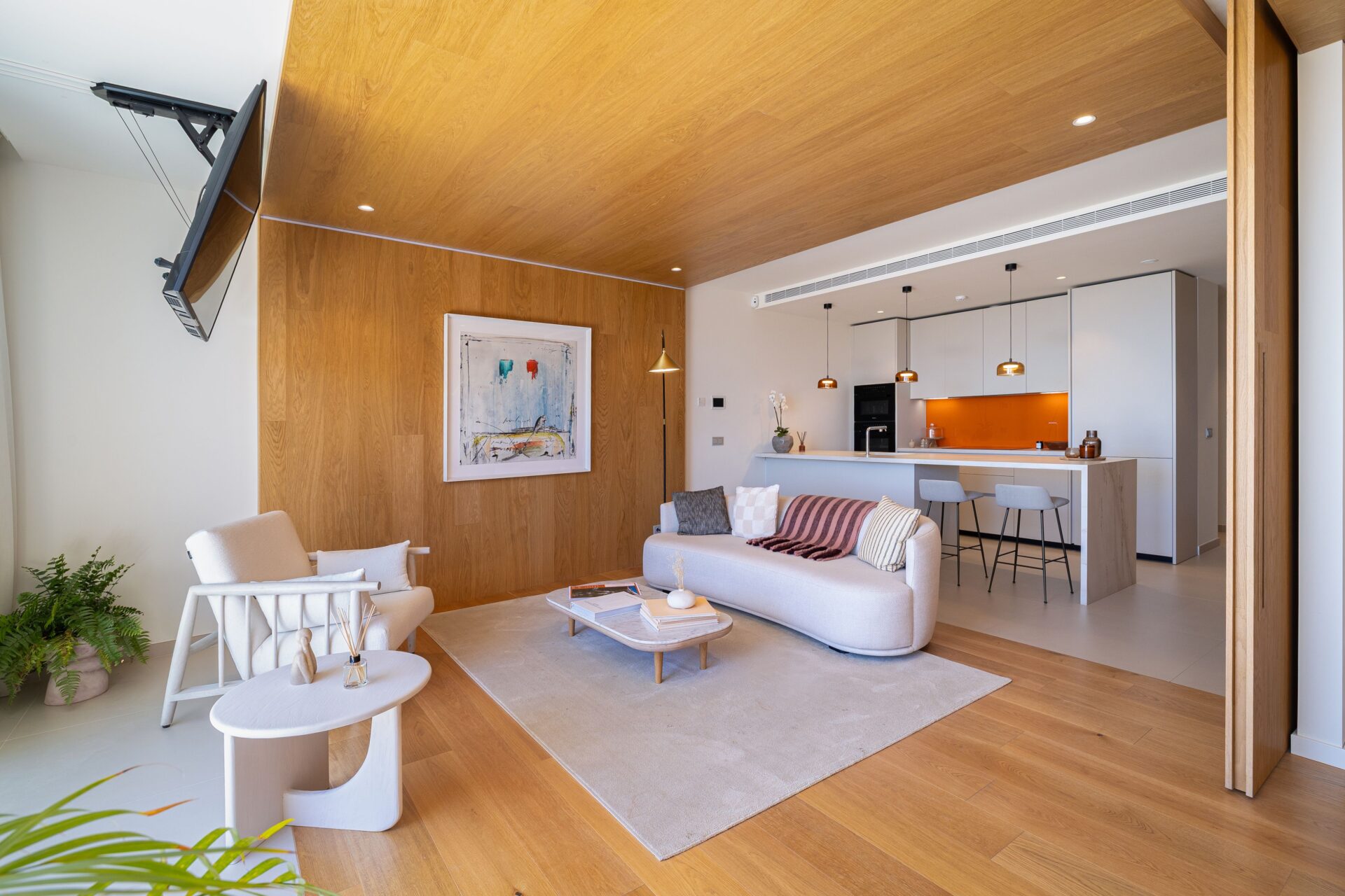 A living room and kitchen in one open room, with oak on one wall and the kitchen along the back. South Residences, El Higuerón, Fuengirola.