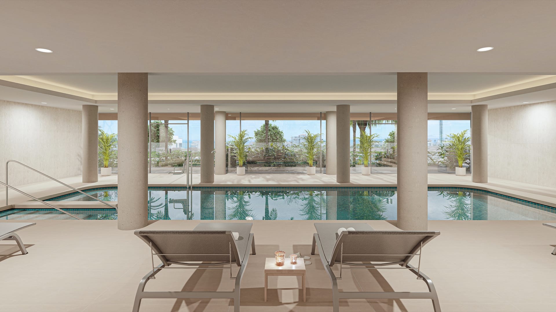 The heated indoor pool, with two loungers in front and windows onto the gardens. South Sand, Las Mesas, Estepona.