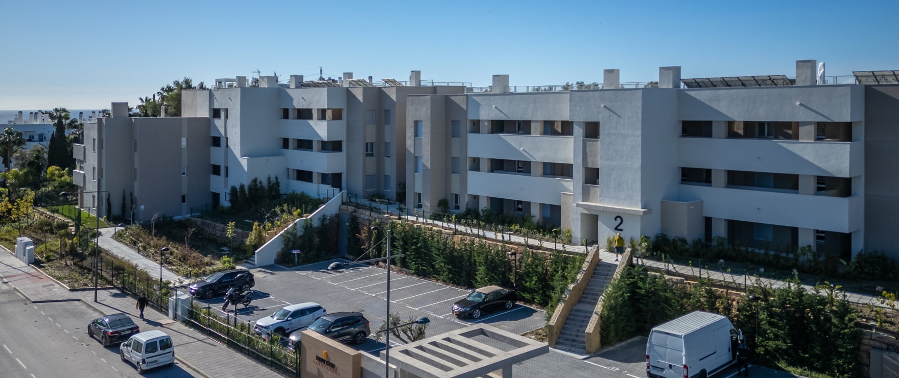 The buildings seen from above the car park, with steps climbing between planted banks. Sunny Golf, Estepona Golf, Estepona.