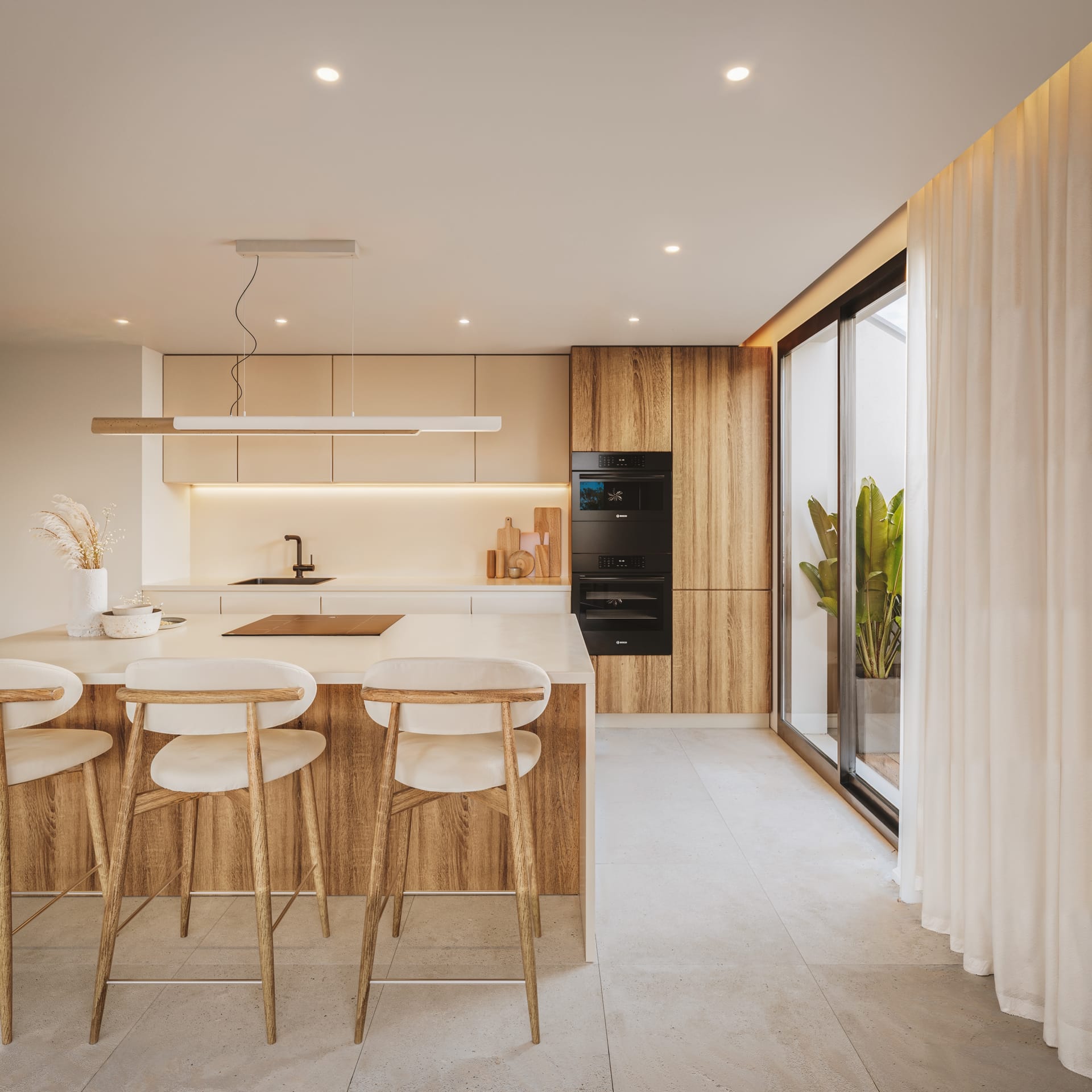 The standard kitchen, in pale wood and white, with an island and stools along it. Torreblanca Heights, Torreblanca, Fuengirola.