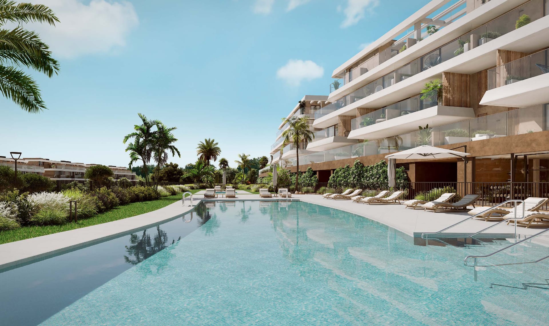 The outdoor pool, with loungers along its edge and the buildings rising behind it. Unika I, Buenas Noches, Estepona.