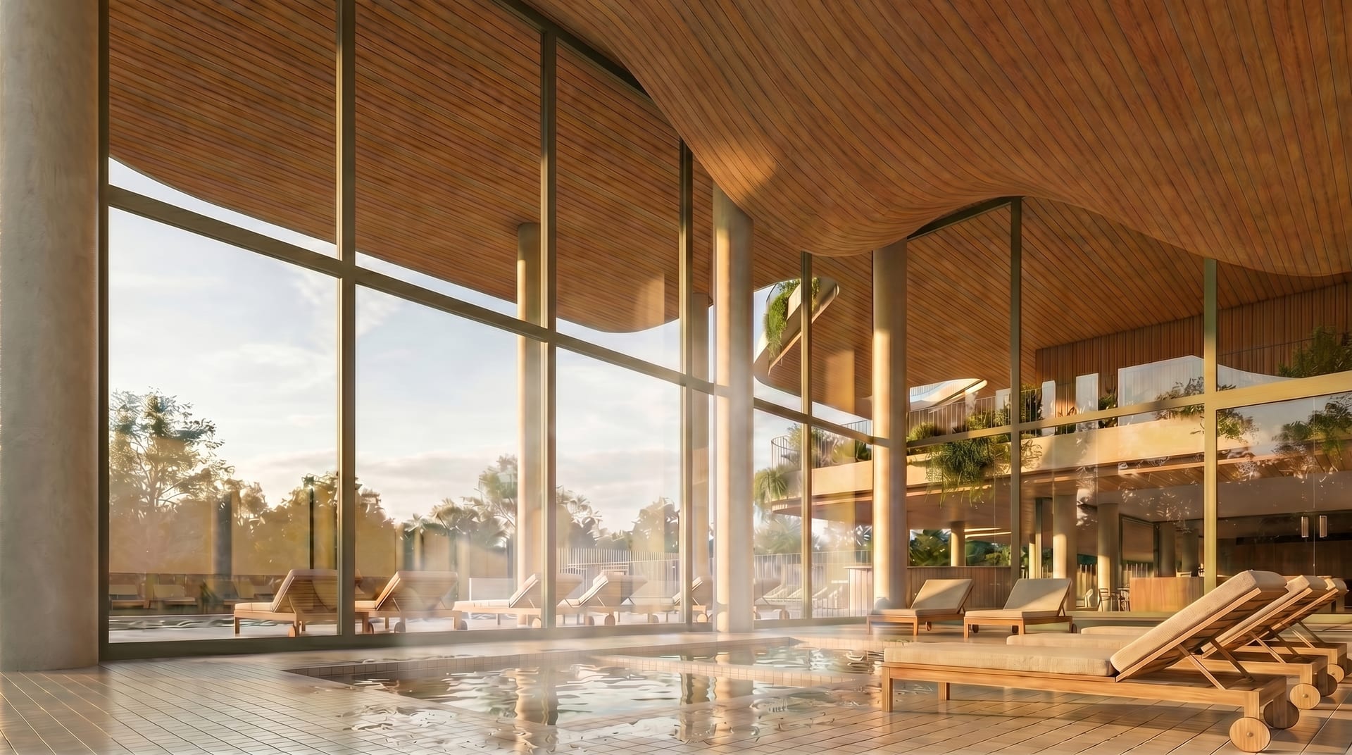 The indoor pool, under a curved timber ceiling, with loungers beside the water and glass walls onto the garden. Vangård, Los Pacos, Fuengirola.