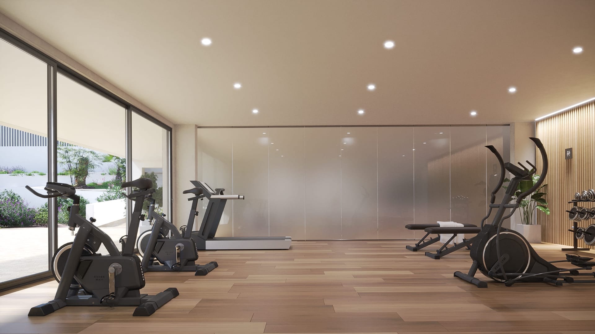The gym, with exercise bikes and a cross-trainer beside a wall of glass. Zenity Blau II, La Gaspara, Estepona.