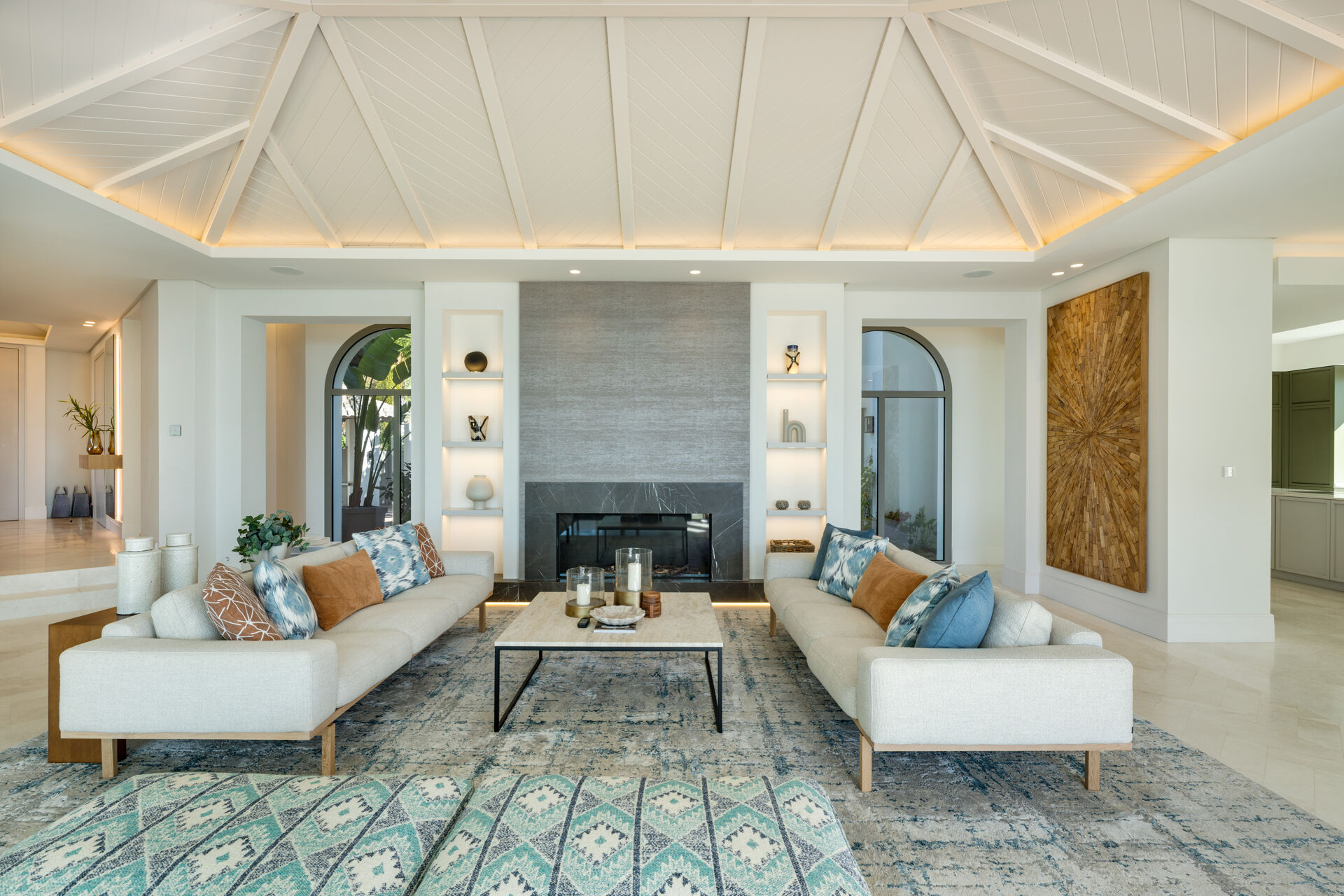 The living room, with a fireplace in the centre wall and a sofa on each side.