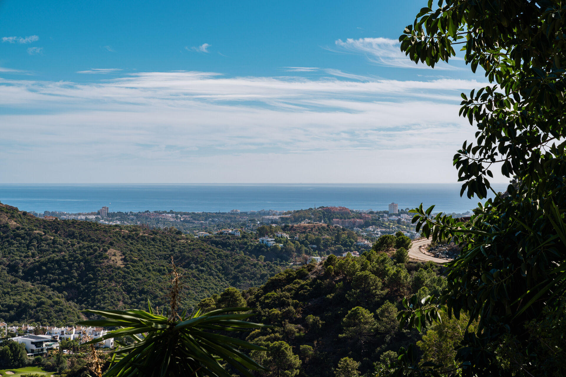 The view from the plot over wooded hills and the coast to the sea.