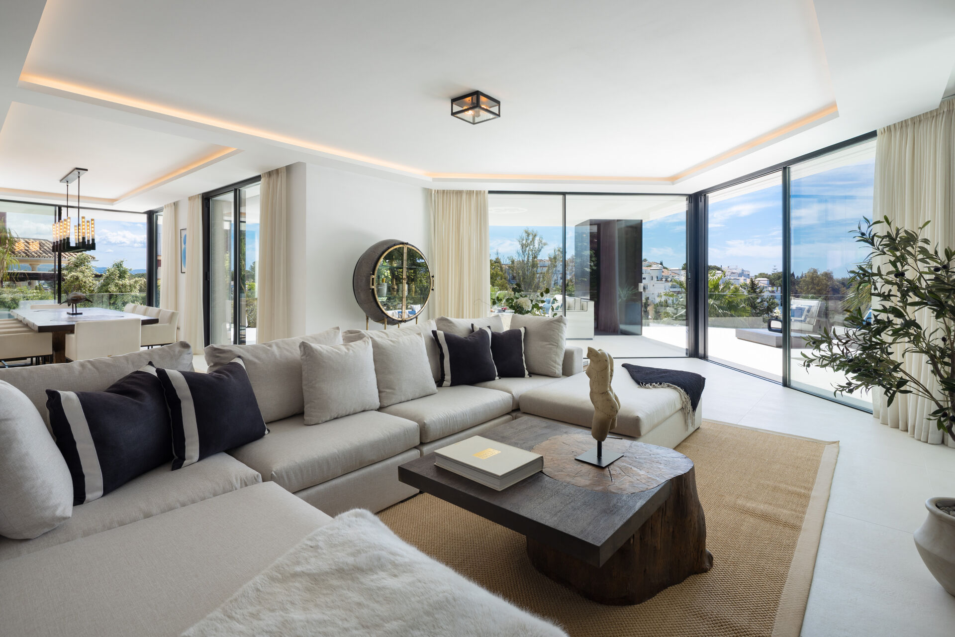 The main living room, with a large corner sofa and sliding glass doors opening onto the terrace.
